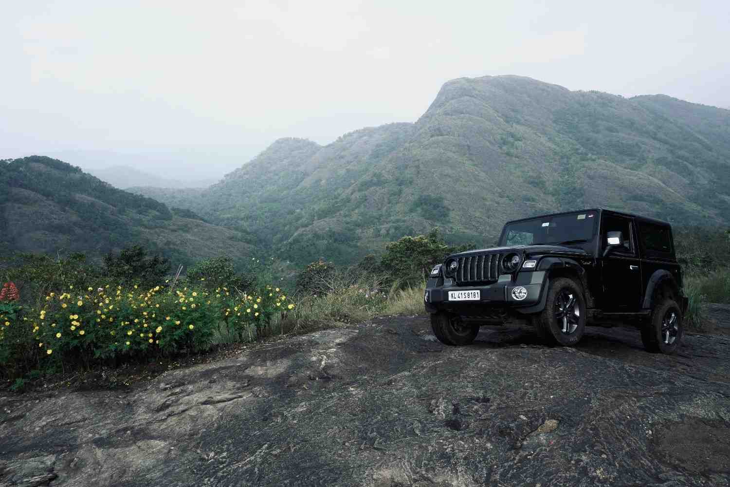 Modern SUV parked safely on a mountain road representing insurance protection